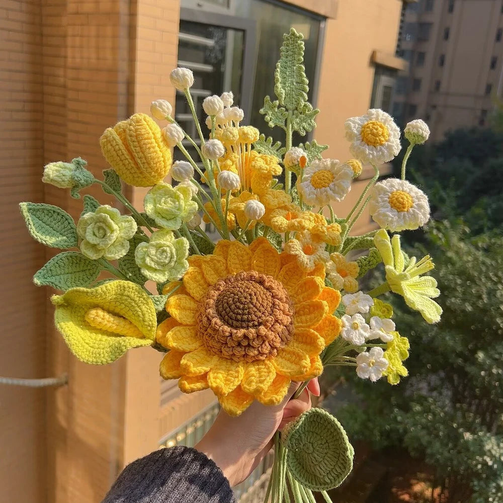 Un ramo de flores de ganchillo hechas a mano en amarillo y blanco, con un gran girasol naranja.