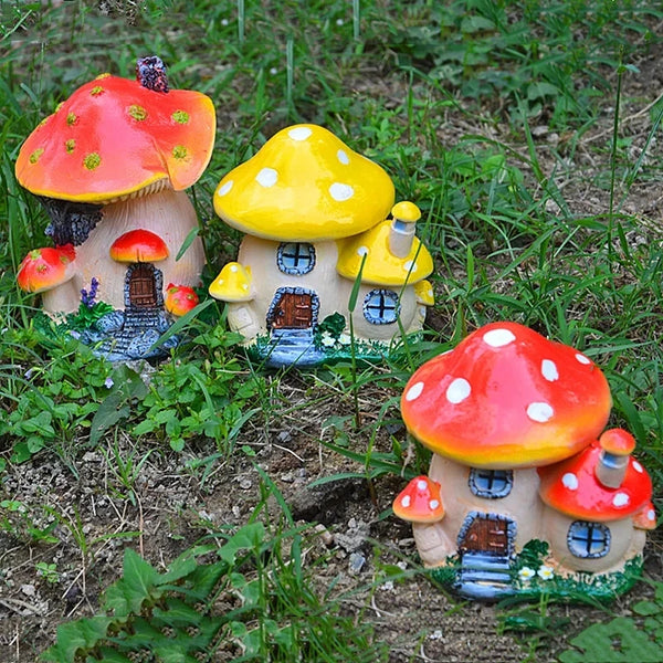 A set of colorful resin mushroom houses and toadstools in a natural garden setting.