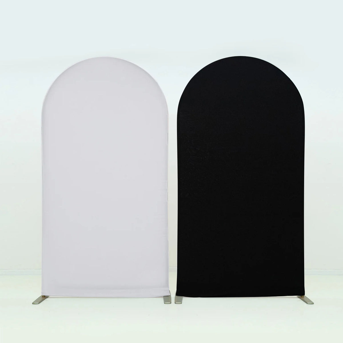 A pair of stretchable arch backdrop covers, one white and one black, displayed against a light background.