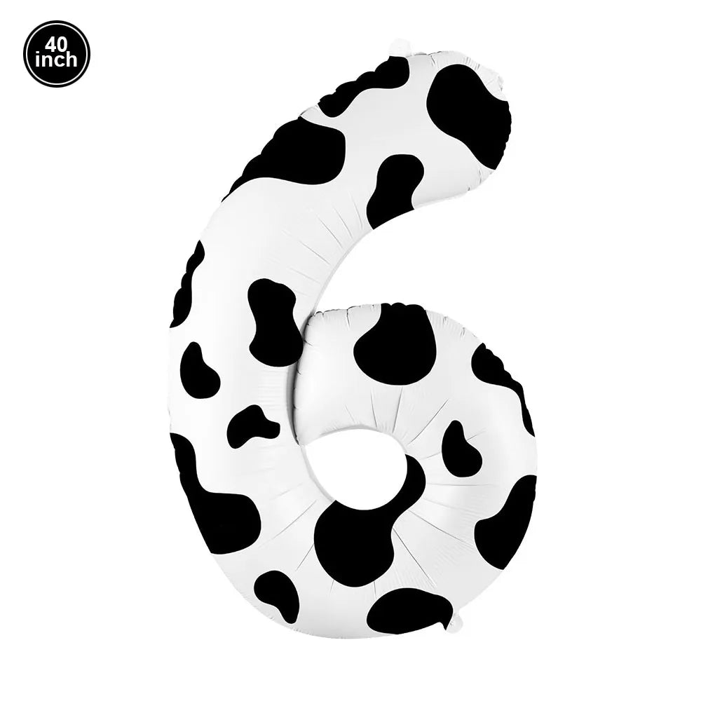 A white cow print number foil balloon shaped like the number 6, used for farm-themed parties.