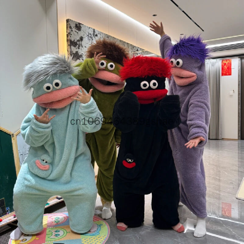 Three people wearing fuzzy monster onesies pajamas in various colors standing indoors