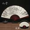 A black and white decorative folding fan with a landscape design is shown, along with a small bronze teapot.