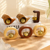 A set of wooden magnetic wind chimes shaped like doorbells with brass chimes resting on a white surface.