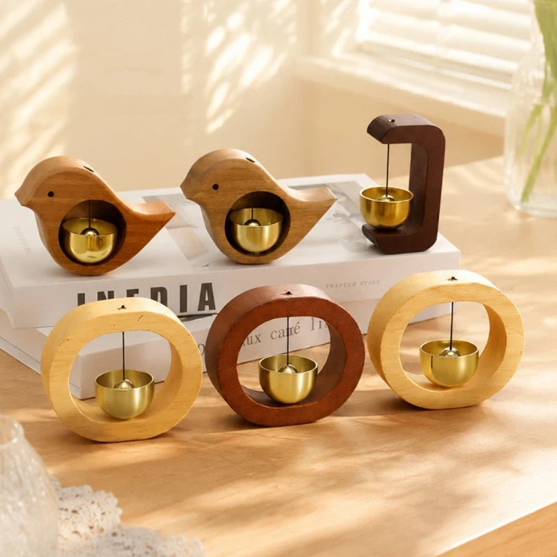 A set of wooden magnetic wind chimes shaped like doorbells with brass chimes resting on a white surface.