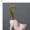 A pink ceramic cartoon cat planter shaped like a feline, holding a green succulent plant with a curved tail.