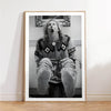 A framed black and white photograph of a person with long hair opening their mouth in surprise or shock.