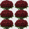 A collection of deep red artificial silk roses arranged in bouquets for table decor.