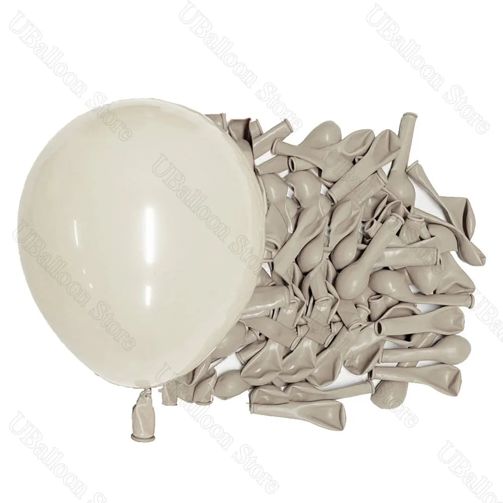 A bunch of latex balloons in neutral shades, including one large white balloon, for baby shower and birthday décor.