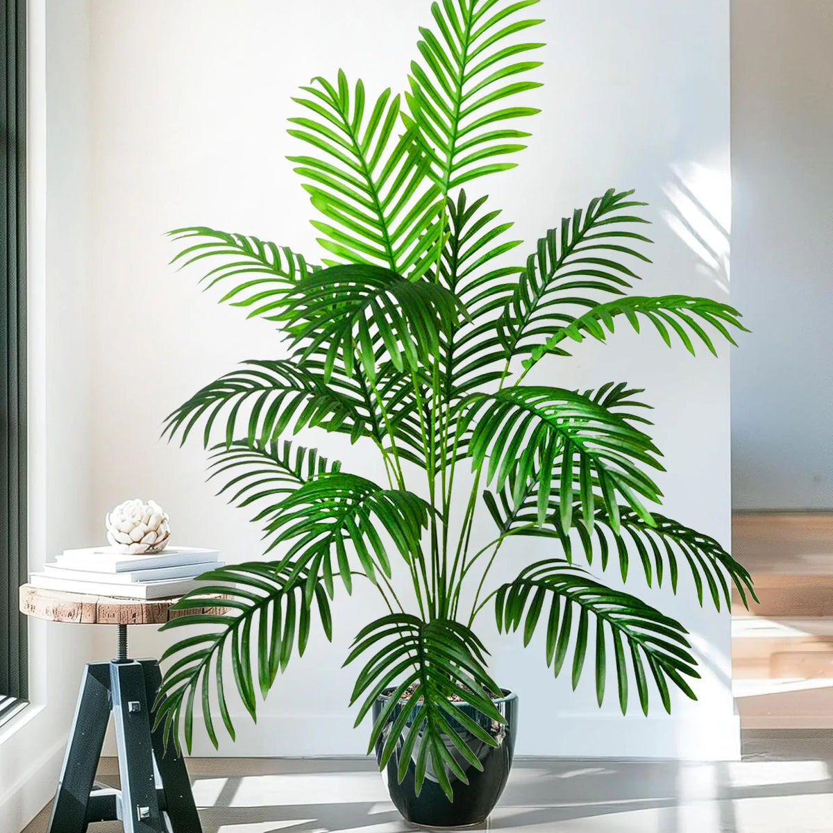 A realistic artificial palm tree with vibrant green silk leaves displayed in a black pot.