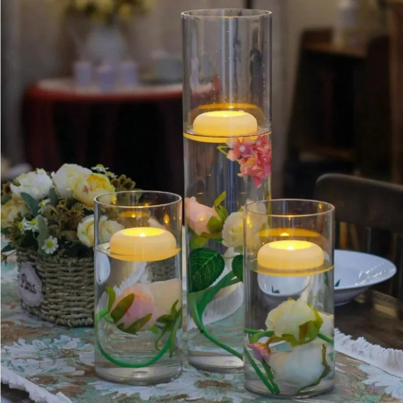 Glass vase filled with pink and white flowers and floating LED tealight candles