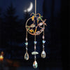 A hanging crystal tree of life sun catcher featuring gold wire and various colored crystals and leaves against a dark backgro