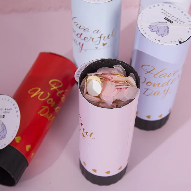 Three hand twist confetti cannons in pink and white packaging are shown against a light background.