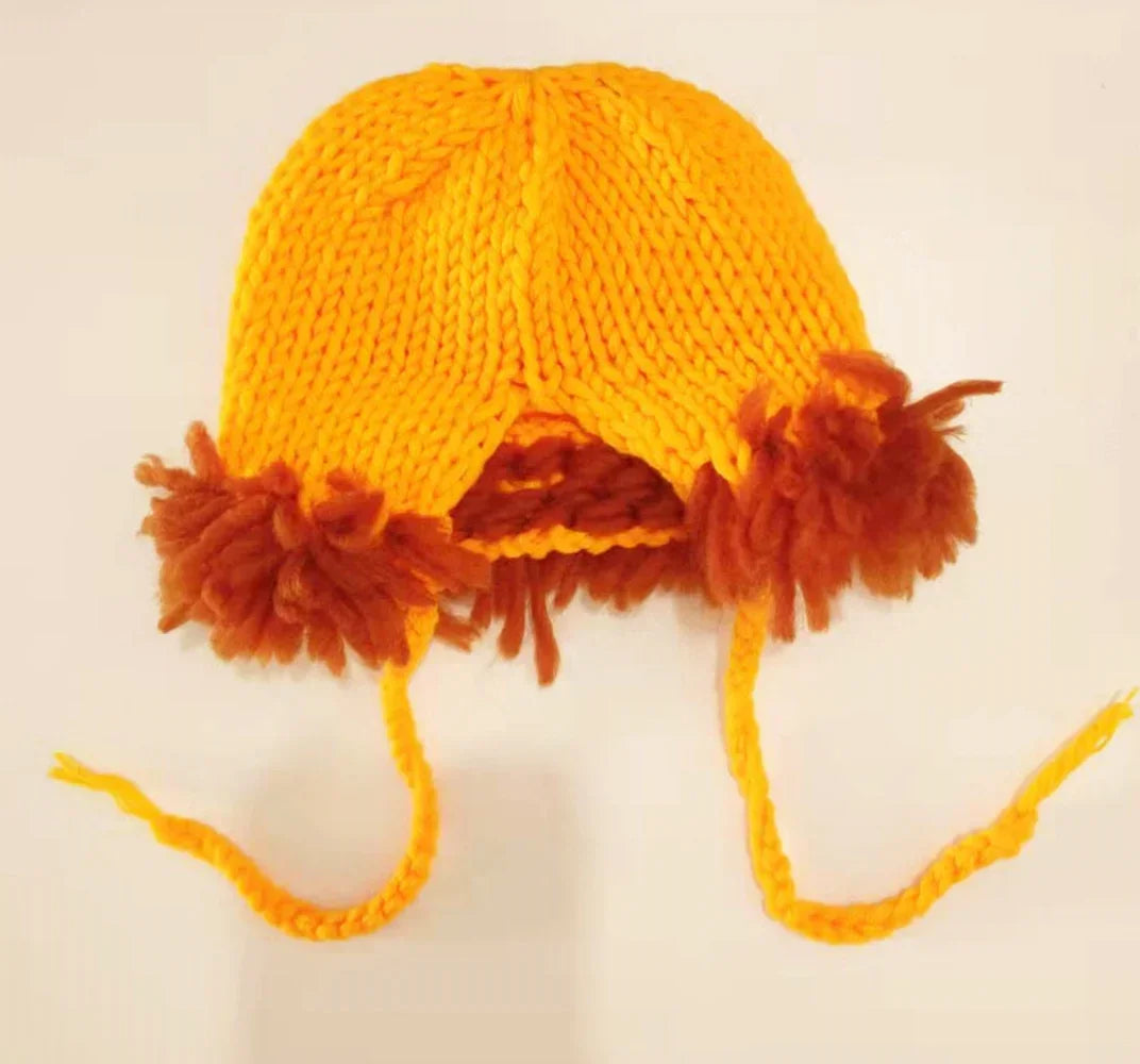An orange handcrafted lion crochet outfit set for baby photo shoots featuring a knitted hat and dangling lion ears.