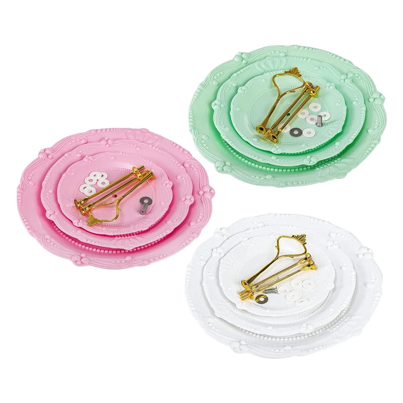 Three stacked plastic cupcake stands in pink, mint green, and white with gold-colored picks.
