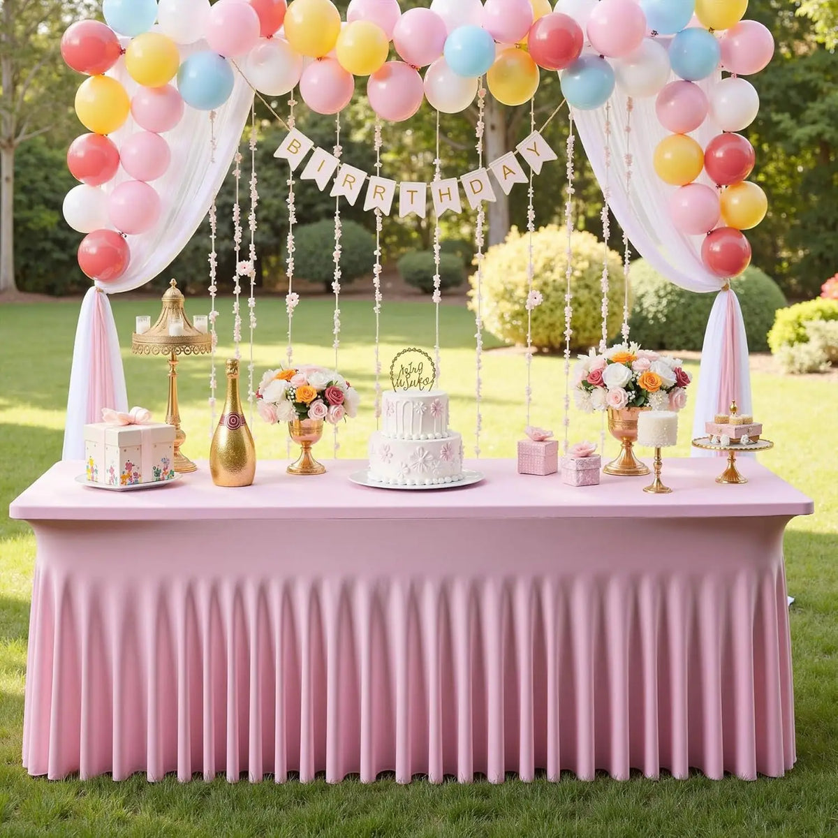 A pink table draped with a wrinkle-free spandex tablecloth cover decorated for a birthday party.