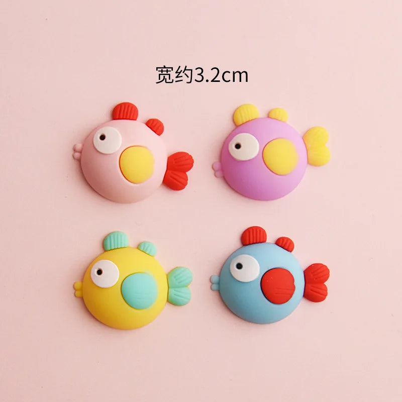 A set of five colorful ocean animal cake toppers including a pink crab, purple turtle, yellow starfish, blue whale, and orang