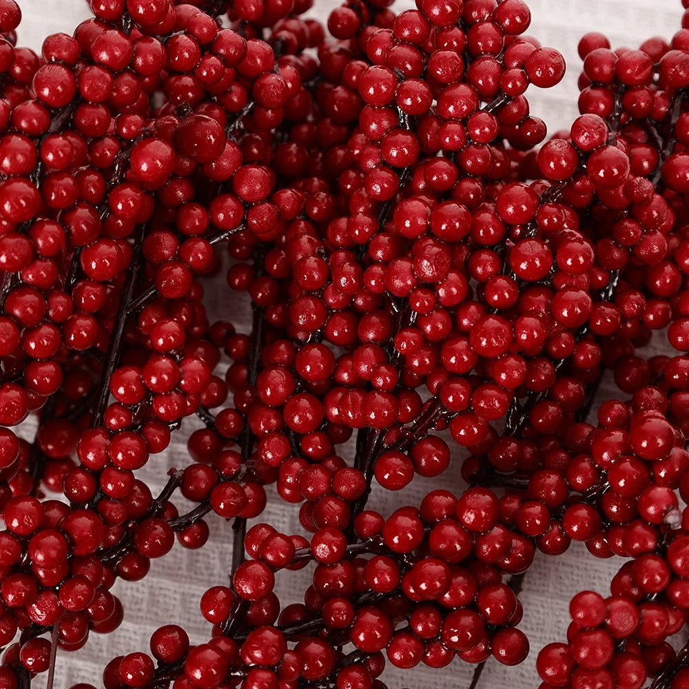 A cluster of artificial red holly berry stems used for Christmas decor.