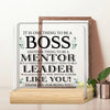 A clear acrylic plaque with text appreciating a boss, mentor, and leader, displayed on a wooden base.