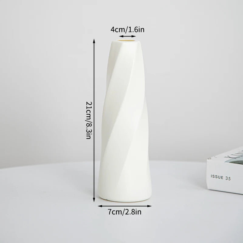 Eine weiße, spiralförmige Plastikblumenvase steht aufrecht auf einer Oberfläche.
