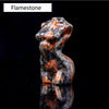 Figura tallada de mineral Flamestone con tonos naranja y blanco moteados, mostrada contra un fondo negro.