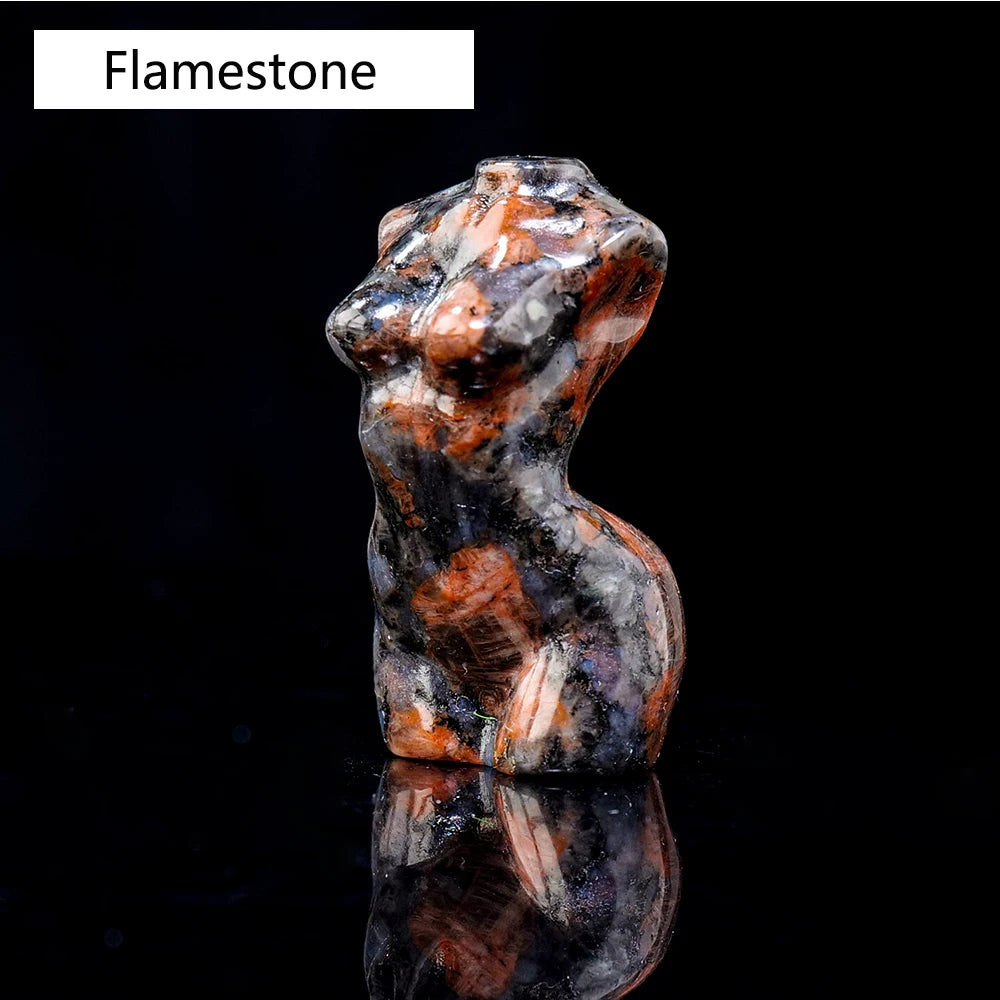 Figura tallada de mineral Flamestone con tonos naranja y blanco moteados, mostrada contra un fondo negro.