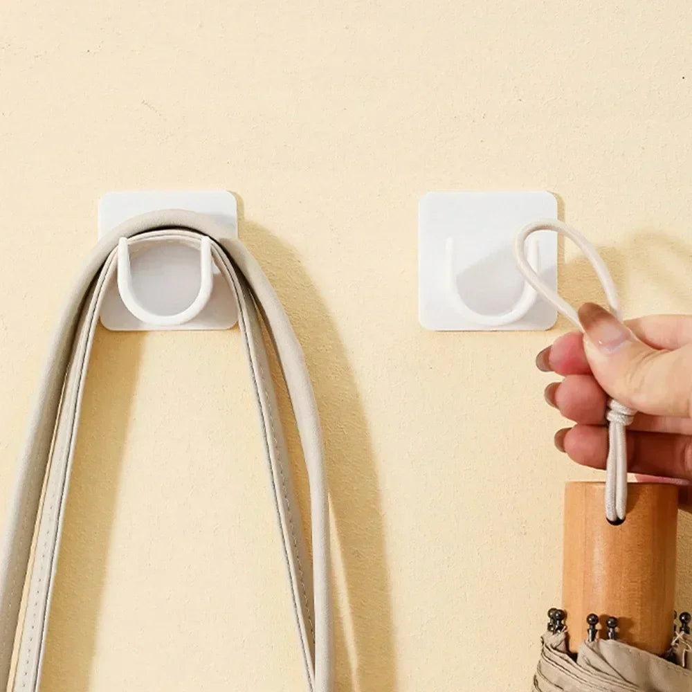 A hand is attaching an adjustable self-adhesive curtain rod bracket to a wall, showing the white bracket and the curved metal