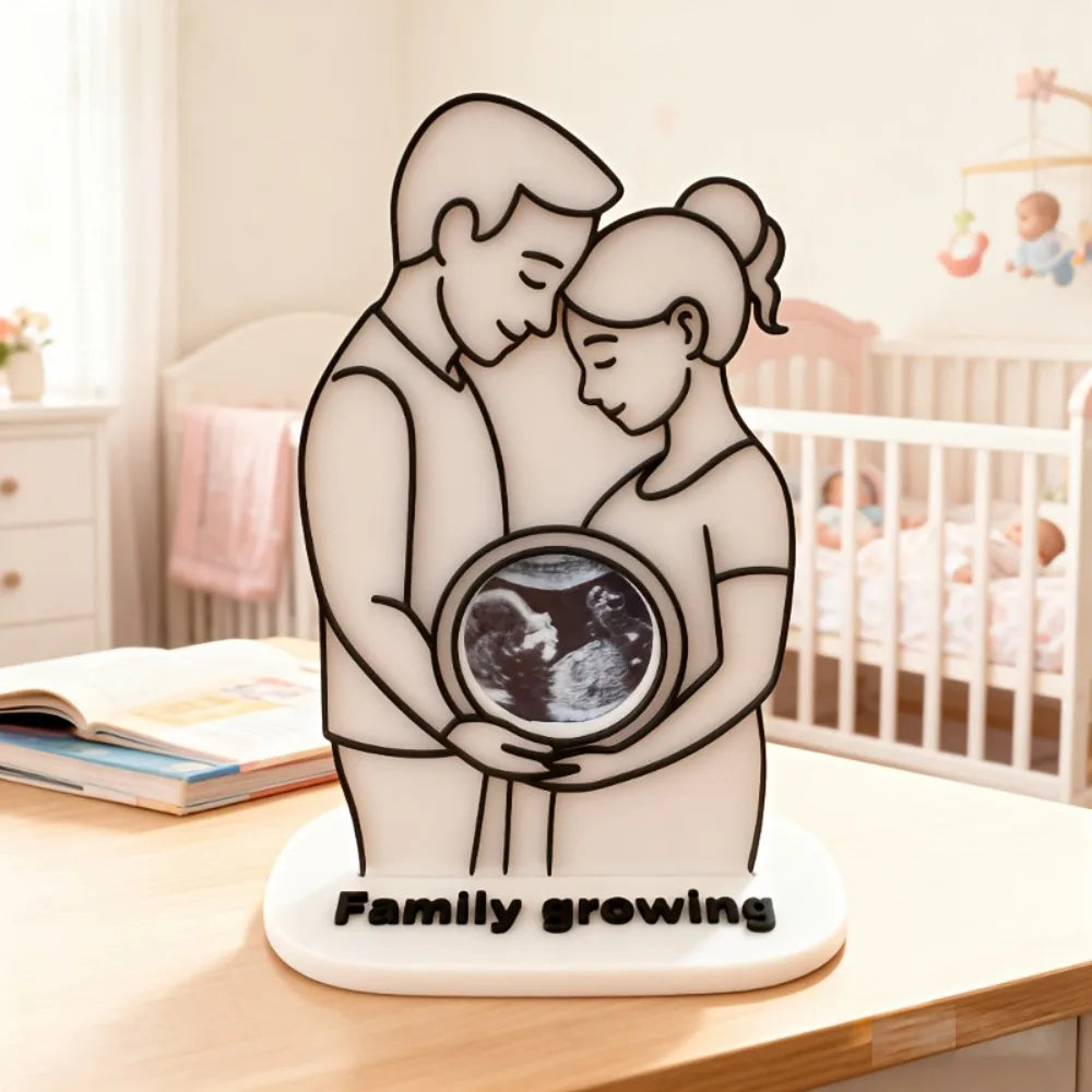 A white silhouette of a mother and baby embracing, with the text Family growing on the base.