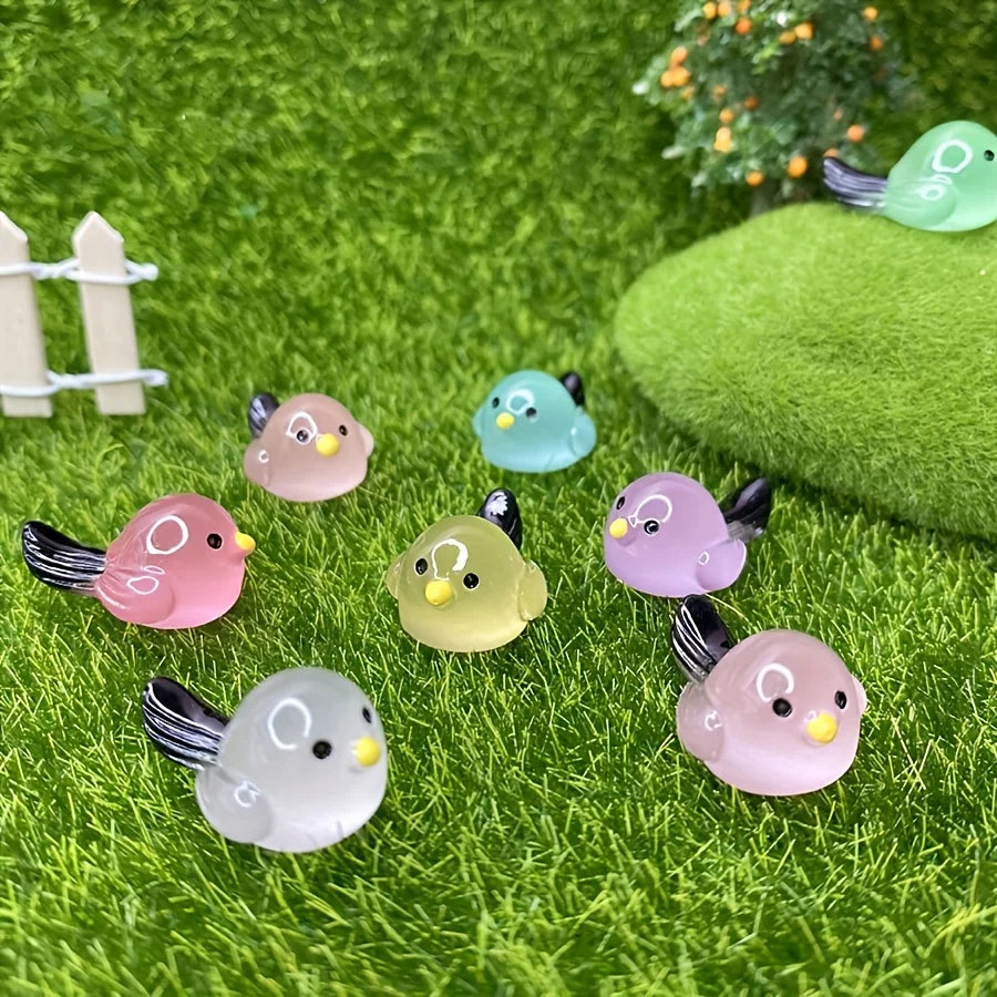 A set of mini luminous resin bird fairy garden decor featuring various pastel colored birds on green moss.