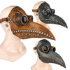A pair of dark metal and leather plague doctor bird masks displayed on a mannequin head.