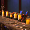 A long wooden table decorated with glowing amber pillar candles and seasonal foliage.