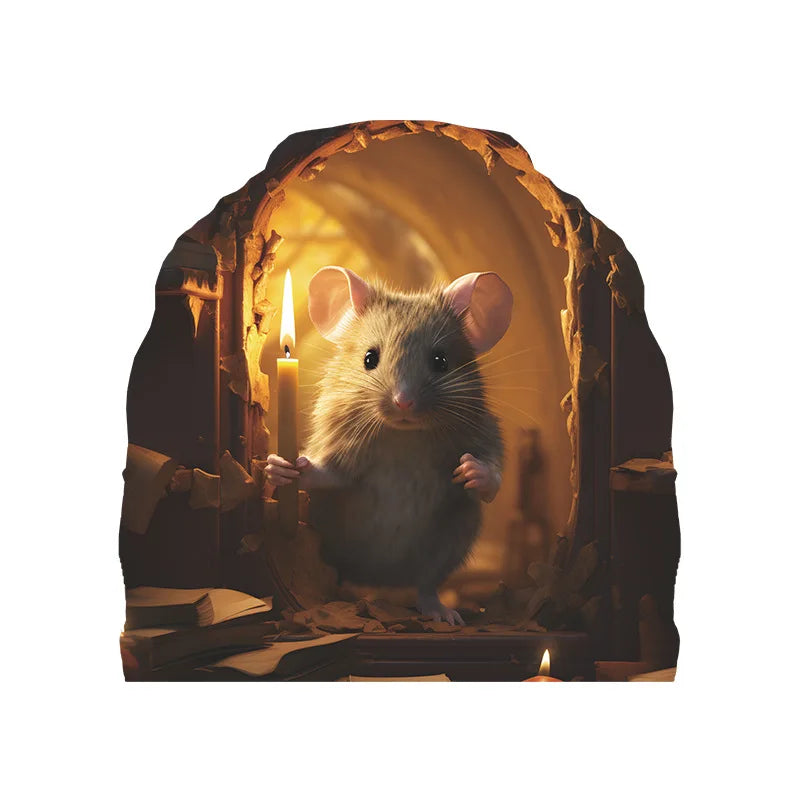 A small gray mouse with large ears sits in an arched wooden frame next to a lit candle.