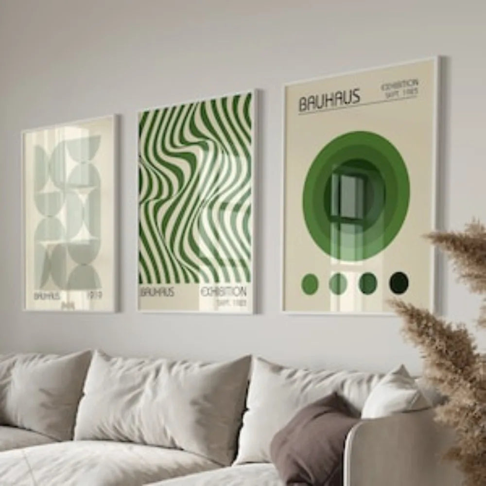 A gallery wall featuring three framed Bauhaus art prints with green and beige tones.