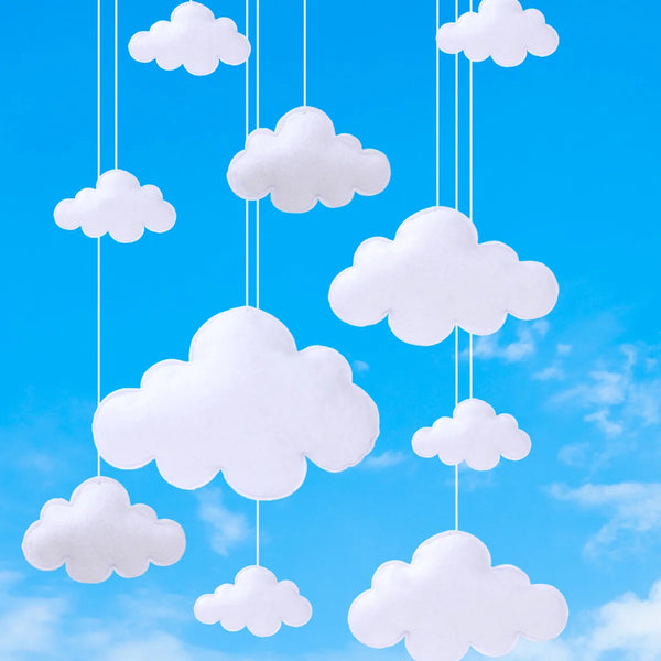 White felt clouds are hanging from strings against a bright blue sky.