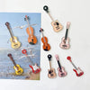 A set of five guitar-shaped fridge magnets in various colors and finishes.