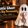 A white ghost figurine with a personality, holding a soda can, displayed on a wooden table in a cozy setting.