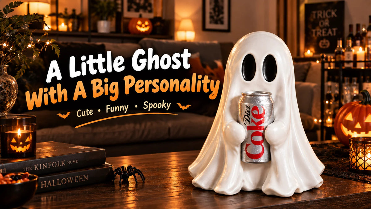 A white ghost figurine with a personality, holding a soda can, displayed on a wooden table in a cozy setting.