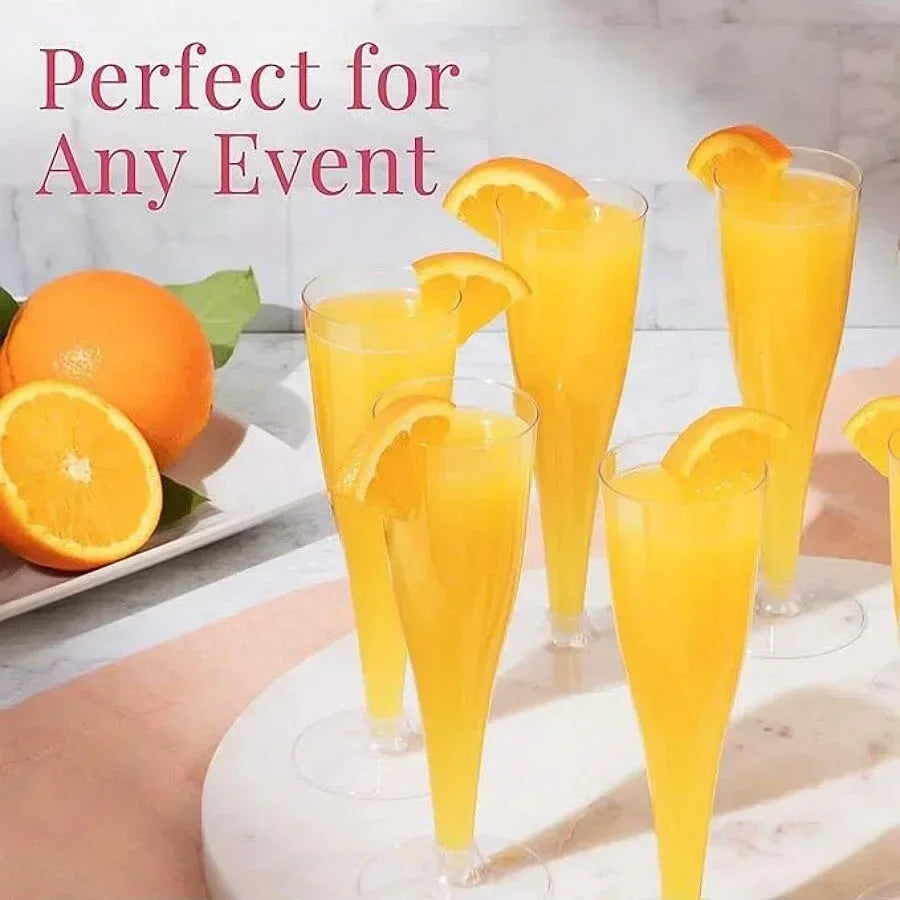 A set of disposable champagne glasses with a gold finish filled with orange juice and garnished with citrus slices.