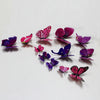 A collection of twelve colorful 3D butterfly wall decor stickers in shades of pink, purple, and magenta.