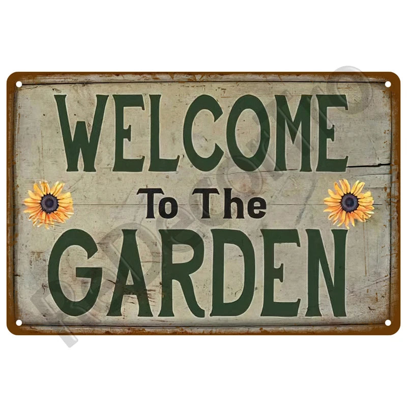 A vintage metal tin sign with distressed paint that reads Welcome to The Garden in green lettering.