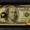 A 100 dollar bill is engulfed in flames against a dark background.
