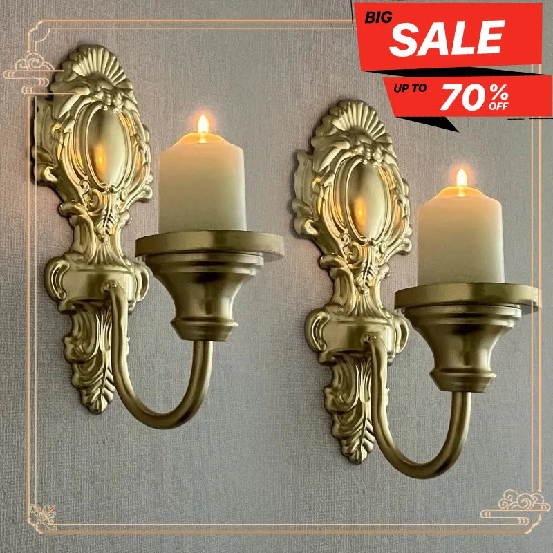 A set of two vintage wrought iron wall-mounted candle holders with white pillar candles.