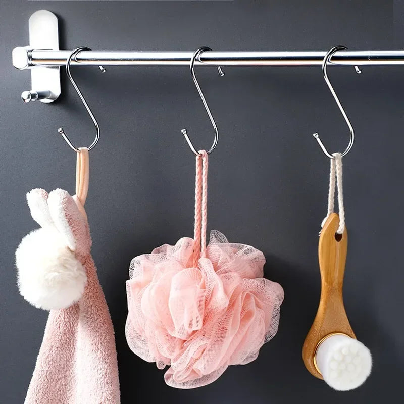 A set of stainless steel hanging hooks with pink and white fabric items are displayed on a rod.