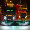 Two red and black trucks with bright LED lights driving at night, featuring green light displays.