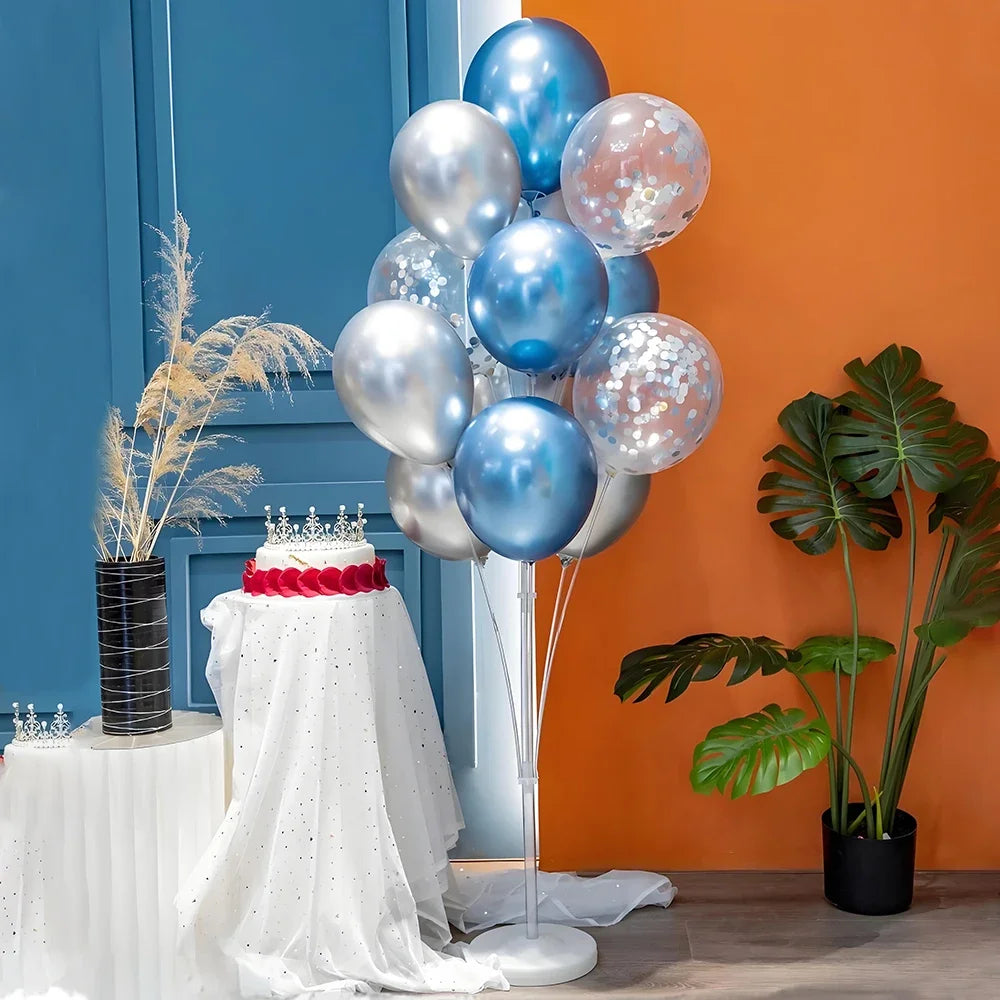 Elegant balloon column stand with silver and blue balloons displayed against an orange wall.