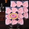 Un set de bougies parfumées en forme de cœur roses emballées dans une boîte transparente.