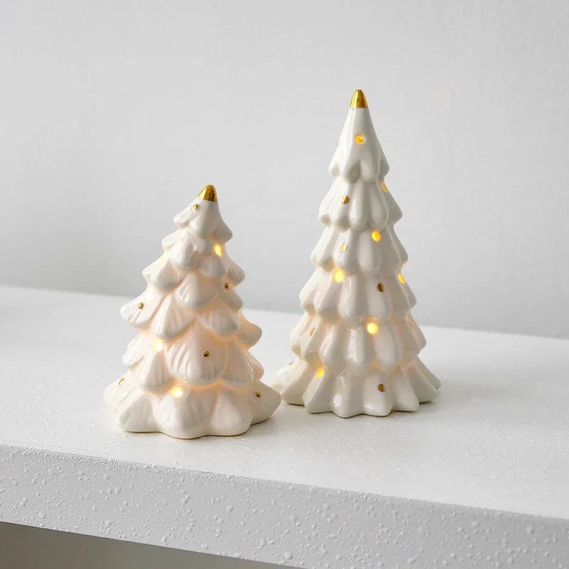 A white ceramic glow-in-the-dark mini Christmas tree decor with warm lights and a gold tip.