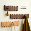Wooden piano keys coat hooks mounted on a white wall, with an additional wooden rack below.