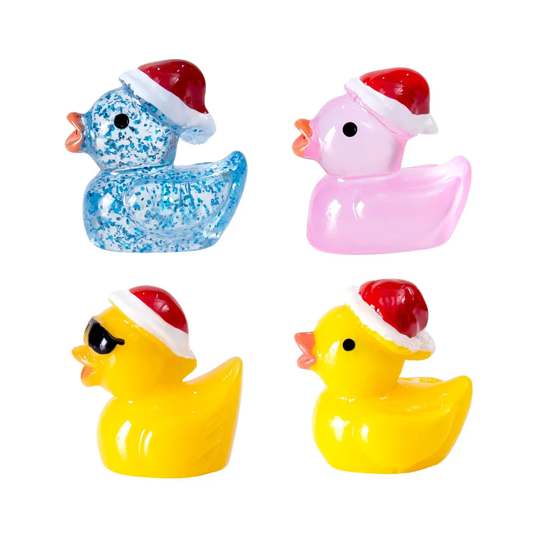 Four glow-in-the-dark Christmas duck figurines with Santa hats in blue, pink, and yellow.