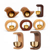 A set of wooden magnetic wind chimes shaped like birds with brass bells, displayed against a white background.