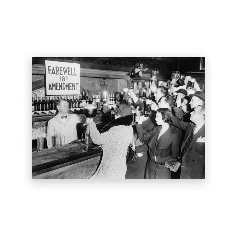 Black and white vintage photograph of a group of people gathered in a dimly lit room.